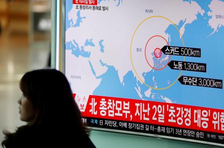 A woman walks past a television broadcasting a news report on North Korea firing ballistic missiles, at a railway station in Seoul, South Korea, March 6, 2017.  REUTERS/Kim Hong-Ji