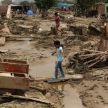 Residents walk on a flooded street, after rivers breached their banks due to torrential rains, causing flooding and widespread destruction in Huachipa, Lima, Peru, March 20,  2017. REUTERS/Mariana Bazo
