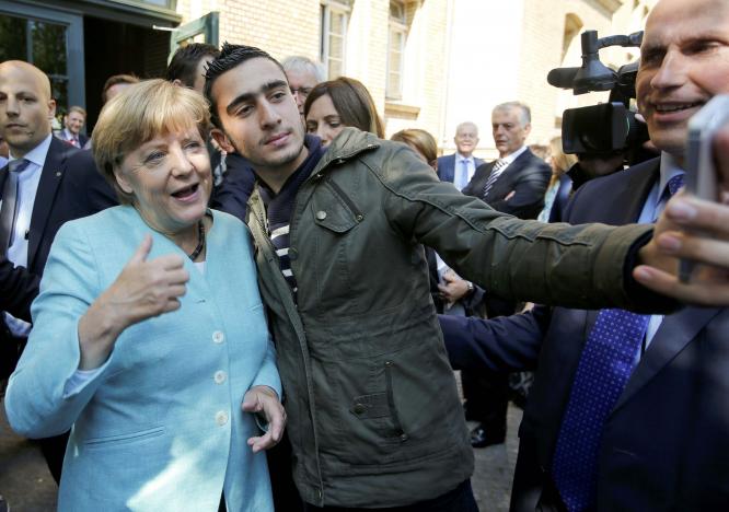 FILE PHOTO: Syrian refugee Anas Modamani takes a selfie with German Chancellor Angela Merkel outside a refugee camp near the Federal Office for Migration and Refugees after registration at Berlin's Spandau district, Germany September 10, 2015.      REUTERS/Fabrizio Bensch/File Photo