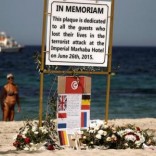 Tourists stand near a plaque dedicated to victims on the beach of the Imperial Marhaba resort, on the first anniversary of an attack by a gunman at the hotel in Sousse, Tunisia June 26, 2016.  REUTERS/Zohra Bensemra