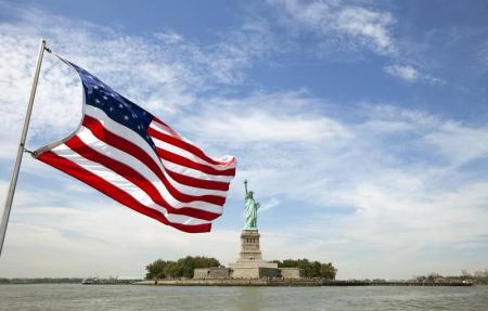 An U.S. flag waves in the wind on a boat near the Statue of Liberty in New York August 31, 2011.  REUTERS/Lucas Jackson