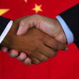 Business team shaking hands in front of the flag