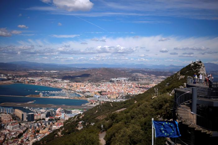 FILE PHOTO: A general view shows the Spanish city of La Linea de la Concepcion (rear) and the tarmac of the Gibraltar International Airport (bottom L) while tourists stand on the top of the Rock (R) next to the European Union flag, in the British overseas territory of Gibraltar, September 14, 2016. REUTERS/Jon Nazca/File Photo