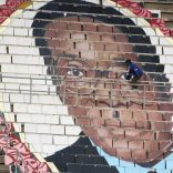 A worker puts final touches on a picture of Zimbabwean President Robert Mugabe at a rally to mark the country's 37th independence anniversary in Harare,  Zimbabwe, April 18, 2017.  REUTERS/Philimon Bulawayo