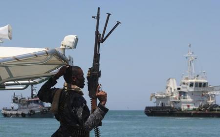 A maritime policeman on a tag-boat guards oil tanker Aris-13, which was released by pirates, as it sails to dock on the shores of the Gulf of Aden in the city of Bosasso, northern Somalia's semi-autonomous region of Puntland, March 19, 2017. REUTERS/Abdiqani Hassan