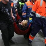 An injured person is helped by emergency services outside Sennaya Ploshchad metro station, following explosions in two train carriages at metro stations in St. Petersburg, Russia April 3, 2017. REUTERS/Anton Vaganov