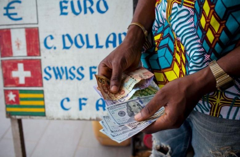 FILE PHOTO: A man trades U.S. dollars for Ghanaian cedis at a currency exchange office in Accra, Ghana, June 15, 2015.  REUTERS/Francis Kokoroko/File Photo