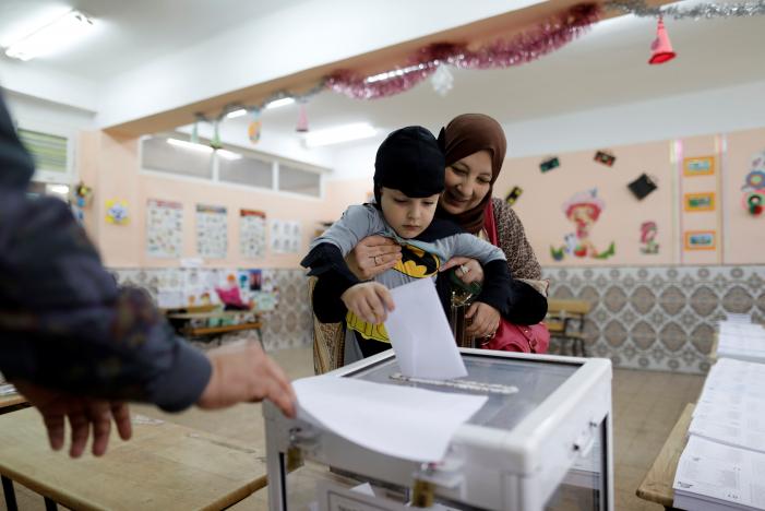 A woman carries her son to cast her vote at a polling station during the parliamentary election in Algiers, Algeria May 4, 2017. REUTERS/Zohra Bensemra