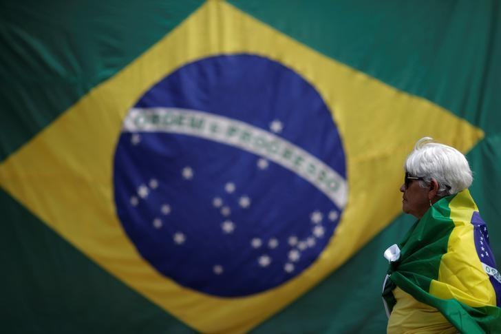 A woman is seen with a Brazilian flag in front of the National Congress during a protest against corruption, in Brasilia, Brazil March 26, 2017. REUTERS/Ueslei Marcelino