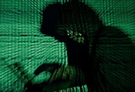 A man holds a laptop computer as cyber code is projected on him in this illustration picture taken on May 13, 2017. REUTERS/Kacper Pempel/Illustration