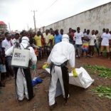 Healthcare workers prepare to remove the body of a man suspected of carrying Ebola in Monrovia, Liberia, July 17, 2015. REUTERS/James Giahyue