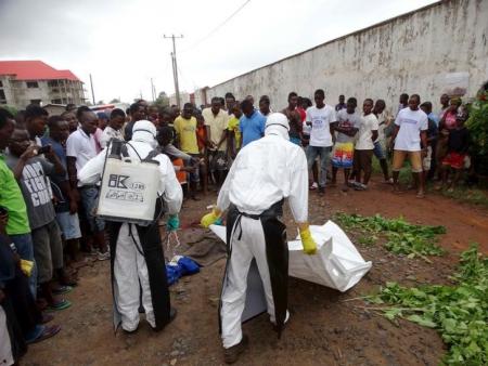 Healthcare workers prepare to remove the body of a man suspected of carrying Ebola in Monrovia, Liberia, July 17, 2015. REUTERS/James Giahyue