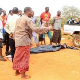 People stand near a body at the scene where a blast killed Kenyan police officers at the Garissa county, eastern Kenya, May 24, 2017. REUTERS/Stringer