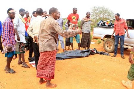 People stand near a body at the scene where a blast killed Kenyan police officers at the Garissa county, eastern Kenya, May 24, 2017. REUTERS/Stringer