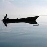 A Ugandan fisherman rows back to his nets at dawn on Uganda's Lake Victoria, March 21,2006.   REUTERS/Euan Denholm