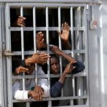 Illegal migrants, who have been detained after trying to get to Europe, look out of barred door of a detention hut at a detention camp in Gheryan, outside Tripoli, Libya December 1, 2016. Picture taken December 1, 2016. REUTERS/Hani Amara