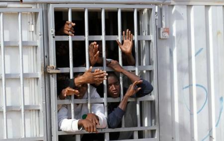Illegal migrants, who have been detained after trying to get to Europe, look out of barred door of a detention hut at a detention camp in Gheryan, outside Tripoli, Libya December 1, 2016. Picture taken December 1, 2016. REUTERS/Hani Amara