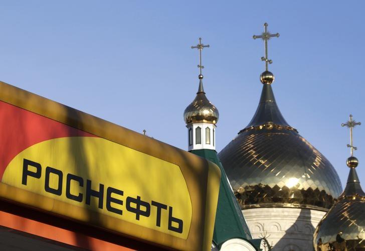 The logo of Russia's top crude producer Rosneft is seen on a gasoline station near a church in Stavropol, southern Russia, December 9, 2014. REUTERS/Eduard Korniyenko/Files