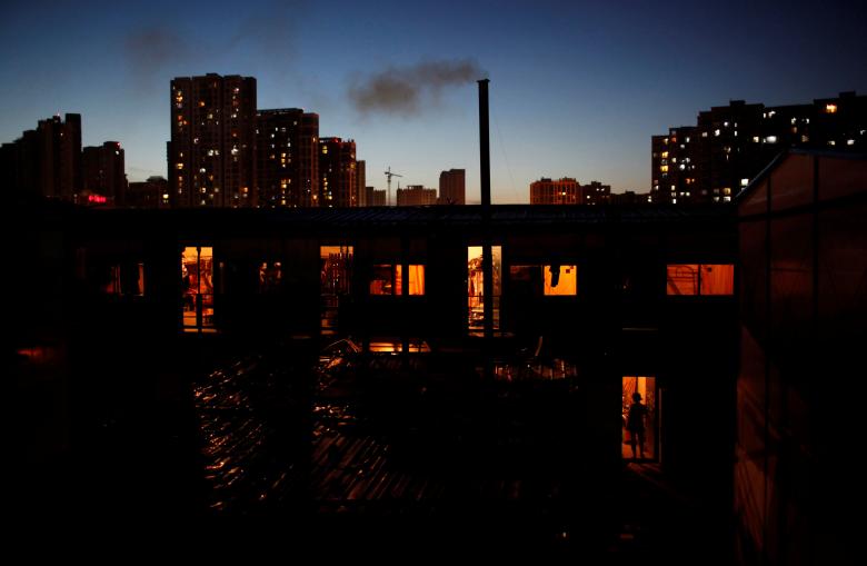 A female migrant construction worker walks into her dormitory near newly-built residential apartments in Shanghai August 12, 2013.  REUTERS/Aly Song/File Photo