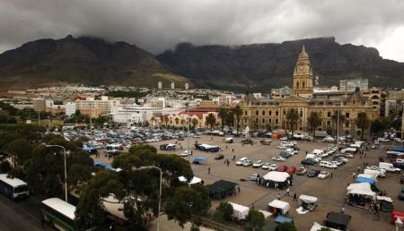 Cape Town's iconic Table Mountain looms behind the City Hall as the clock strikes noon above informal traders at the city's Grand Parade March 30, 2012. REUTERS/Mike Hutchings