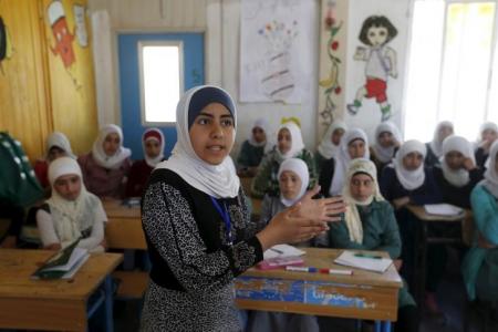 Syrian refugee Omayma al Hushan, 14, who launched an initiative against child marriage among Syrian refugees, speaks to her friends about her initiative at a school in Al Zaatari refugee camp in the Jordanian city of Mafraq, near the border with Syria, April 21, 2016. REUTERS/Muhammad Hamed