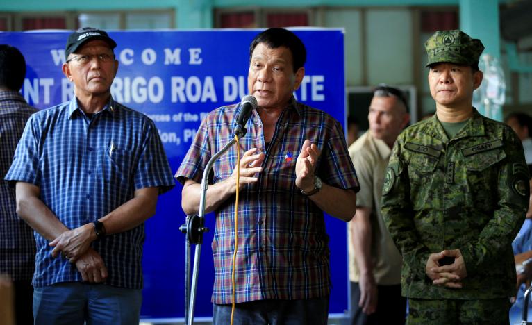 Philippines' President Rodrigo Duterte (C) with Defence Secretary Delfin Lorenzana (L) and General Eduardo Ano, talks after visiting wounded soldiers who fight against the insurgents of the Maute group, which has taken over large parts of the Marawi city, at a military camp in Cagayan De Oro, Philippines June 11, 2017. REUTERS/Romeo Ranoco