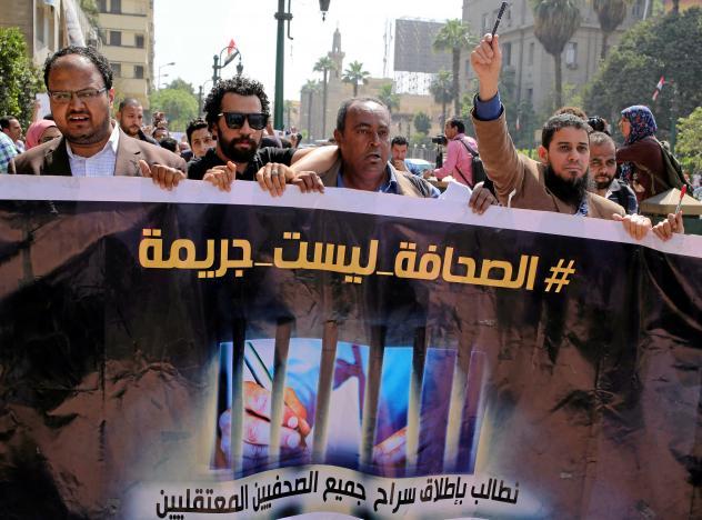 FILE PHOTO: Egyptian journalists hold a banner outside the Egyptian Press Syndicate in downtown Cairo, Egypt April 28, 2016. The banner reads "Press is not a crime." REUTERS/Mohamed Abd El Ghany/File Photo