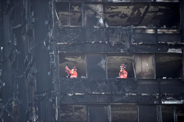 Members of the emergency services work inside the charred remains of the Grenfell apartment tower block in North Kensington, London, Britain, June 17, 2017. REUTERS/Hannah McKay
