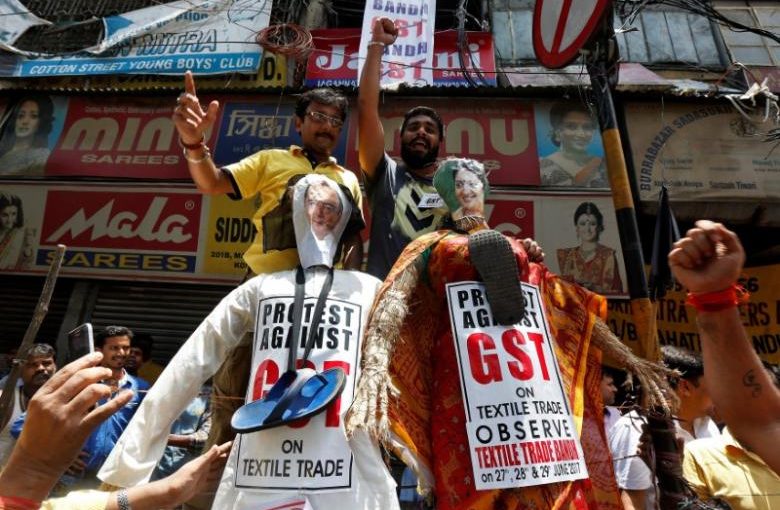Cloth merchants and workers shout slogans before burning the effigies depicting India's Finance Minister Arun Jaitley and Textiles Minister Smriti Irani during a protest against implementation of Goods and Services Tax (GST) on textiles, in Kolkata, India, June 29, 2017. REUTERS/Rupak De Chowdhuri