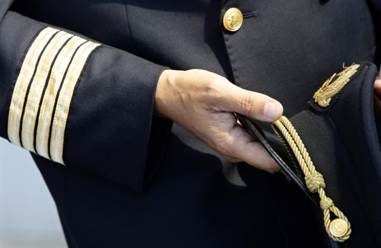 FILE PHOTO: An Alitalia pilot holds his cap at Fiumicino international airport in Rome September 24, 2008.  REUTERS/Max Rossi