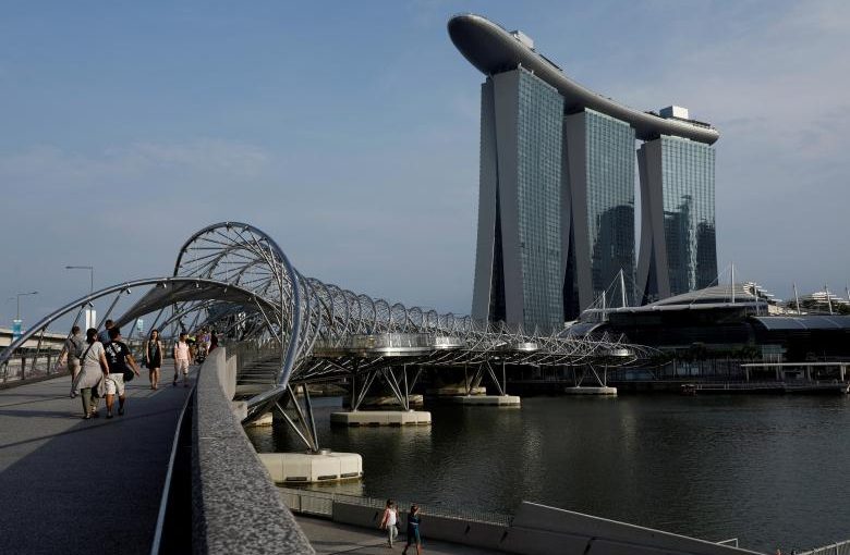 FILE PHOTO: People walk past the Marina Bay Sands hotel in Singapore April 10, 2017. REUTERS/Edgar Su/File Photo