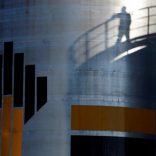 FILE PHOTO: The shadow of a worker is seen besdide the logo of the Rosneft oil company at an oil field in Russia, August 4, 2016. REUTERS/Sergei Karpukhin/File Photo