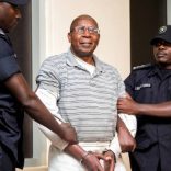 The National Police Rwanda presenting Genocide suspect Dr Leopold Munyakazi to the media before he was taken for an interrogation at the airport. (Photo: Faustin Niyigena, New Times Rwanda)