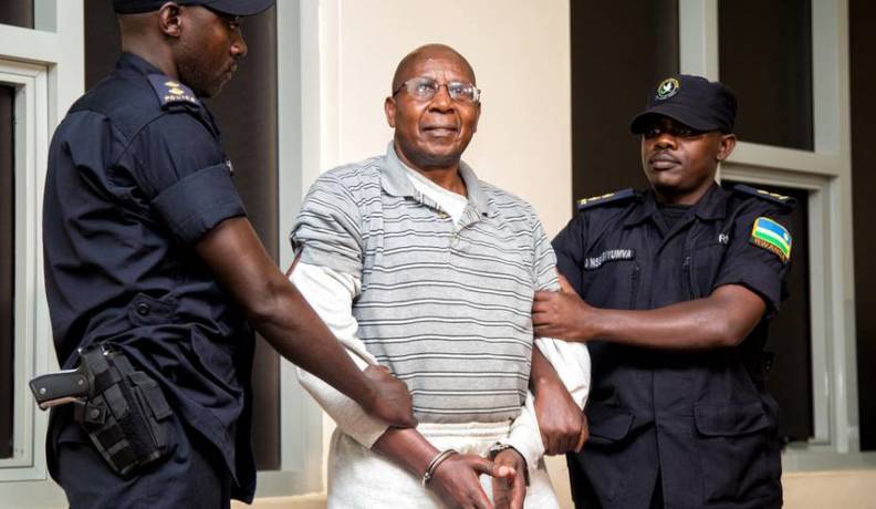 The National Police Rwanda presenting Genocide suspect Dr Leopold Munyakazi to the media before he was taken for an interrogation at the airport. (Photo: Faustin Niyigena, New Times Rwanda)