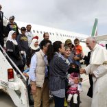 FILE PHOTO: Pope Francis welcomes a group of Syrian refugees after landing at Ciampino airport in Rome following a visit at the Moria refugee camp in the Greek island of Lesbos, April 16, 2016. REUTERS/ Filippo Monteforte