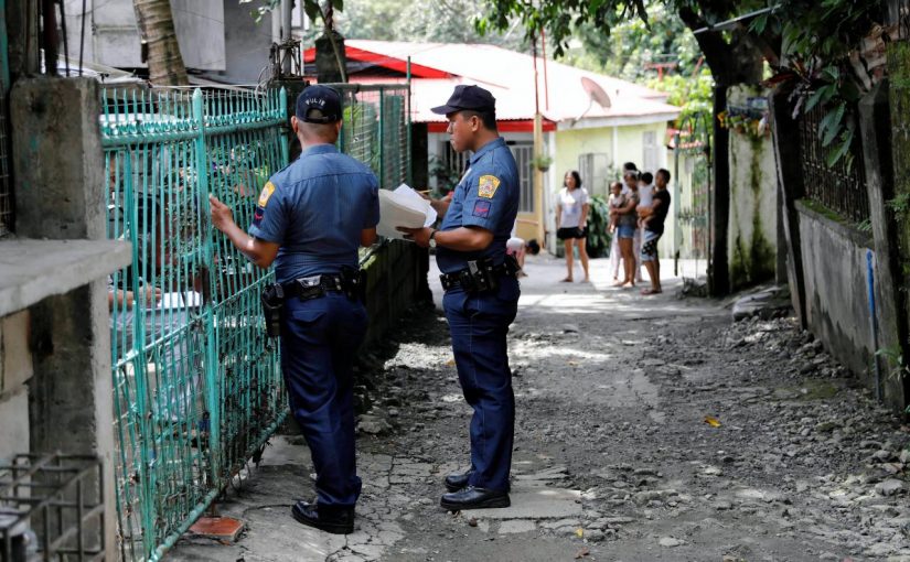 Policemen knock door to door and interview residents during a drug testing operation in Payatas, Quezon City, Metro Manila