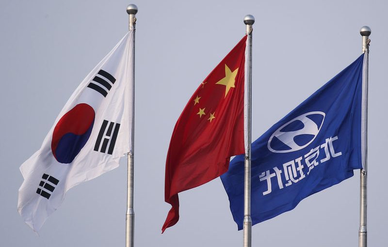 The South Korean and Chinese national flags fly alongside the company flag of Hyundai Motor Co at its plant in Beijing, China, August 30, 2017.   REUTERS/Thomas Peter