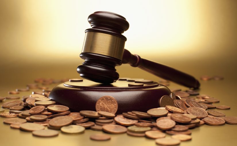 Gavel and sound block surrounded by euro coins