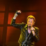 (FILES) A file photo taken on June 2, 2013 shows French singer Johnny Hallyday gesturing as he performs on stage in Bordeaux, southwestern France.  
France's best-known rock star Johnny Hallyday has died aged 74 after a battle with lung cancer, his wife Laeticia told AFP on December 6, 2017. / AFP PHOTO / NICOLAS TUCAT
