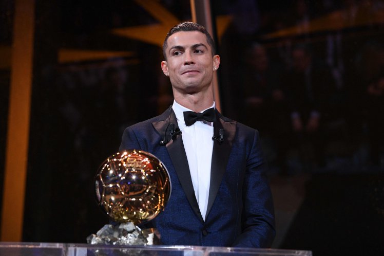 This handout photo released on December 7, 2017 by L'Equipe shows Portugese player Cristiano Ronaldo posing with the Ballon d'Or France Football trophy in Paris. Portuguese star Cristiano Ronaldo won a record-equalling fifth Ballon d'Or (2008, 2013, 2015, 2016 and 2017) award for the year's best player on December 7. The Real Madrid forward's second successive win draws him level alongside Barcelona rival Lionel Messi on five Ballon d'Ors, after beating the Argentinian and Brazilian Neymar. / AFP PHOTO / L'EQUIPE / Franck FAUGERE / RESTRICTED TO EDITORIAL USE - MANDATORY CREDIT "AFP PHOTO / LEQUIPE / FRANCK FAUGERE" - NO MARKETING NO ADVERTISING CAMPAIGNS - DISTRIBUTED AS A SERVICE TO CLIENTS  FRANCK FAUGERE/AFP/Getty Images