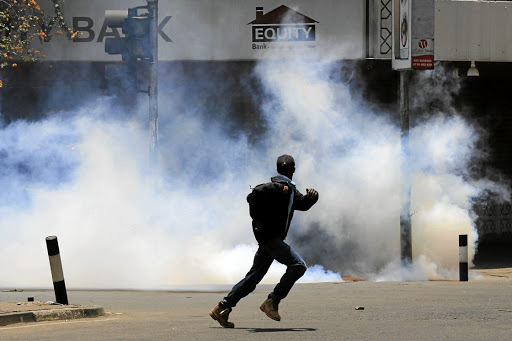 A protester runs away from tear gas during a protest by opposition supporters against against the retention of the election officials they blame for last month's botched elections, in Nairobi, Kenya October 2, 2017. REUTERS/Thomas Mukoya