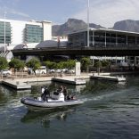 Police patrol a canal near the Cape Town International Convention Centre December 3, 2009. The final draw, involving the 32 teams that qualified for the 2010 Soccer World Cup, takes place on Friday evening at the convention centre and will see 1,000 police deployed to protect dignitaries. Soccer stars such as David Beckham are expected to attend.    REUTERS/Rogan Ward (SOUTH AFRICA SPORT SOCCER) - RTXREUC