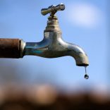 Water drop falling from an old tap