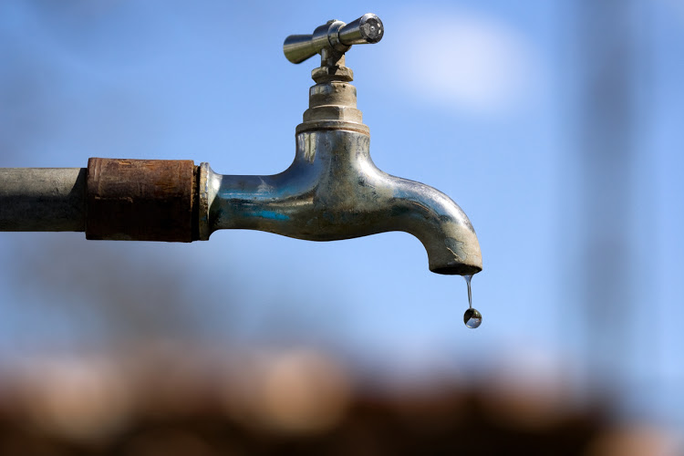 Water drop falling from an old tap