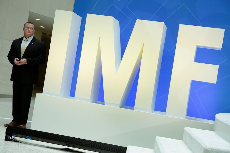 A security personnel stands next to International Monetary Fund logo at IMF headquarters in Washington, U.S., April 19, 2017. REUTERS/Yuri Gripas